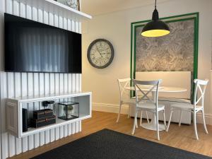 a dining room with a table and a clock on the wall at Casa "Vô Lando" - Nazaré - Alojamento Local in Nazaré