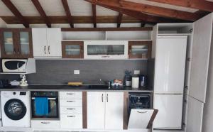 a kitchen with white cabinets and a white refrigerator at Queen Victoria (Куин Виктория) in Kranevo