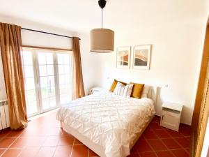 ein Schlafzimmer mit einem Bett und einem großen Fenster in der Unterkunft Villa in Praia D'el Rey, Beach & Golf Resort in Casal da Lagoa Seca + 30 Fotos