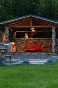 a red couch sitting under a stone wall at Cabana Ruth in Valea Ierii