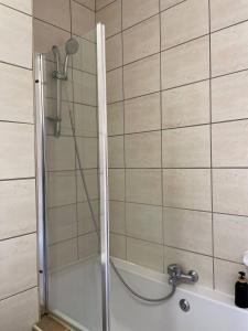 a shower with a glass door in a bathroom at H&H Self-catering in Windhoek