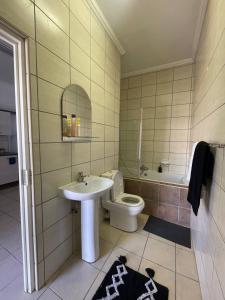een badkamer met een wastafel, een toilet en een bad bij H&H Self-catering in Windhoek