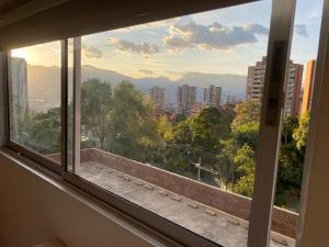 une fenêtre avec vue sur la ville dans l'établissement Apartasuite moderna - en el corazón del poblado medellín, à Medellín