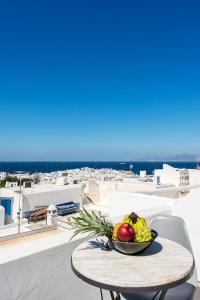 a bowl of fruit sitting on a table on a balcony at Brand New Mykonos Town Suites in Mikonos