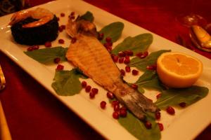 un piatto di cibo con un pesce e un'arancia sopra di Hotel Rosa Blu a Tirana