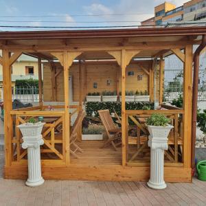 a wooden gazebo with a table and chairs at My Apartments Durres in Durrës