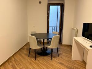 una sala da pranzo con tavolo e sedie in una stanza di La Dimora del Coach a L'Aquila