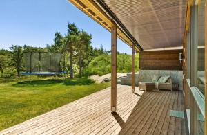 une terrasse couverte avec un canapé et un trampoline dans l'établissement Family-Friendly Apartment close to the beach, à Rød