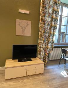 a living room with a flat screen tv on a cabinet at Creton apartment -La casa nel cuore della città- CIR 0121 in Aosta