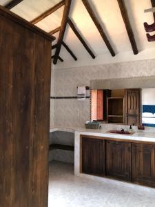 a kitchen with wooden cabinets and a bath tub at Rustico Hostel Barichara in Barichara
