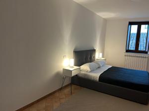 una camera da letto con un letto con due lampade sopra di La Dimora del Coach a L'Aquila