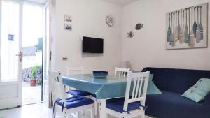 a dining room with a blue table and chairs at Casetta Emilia vicino al mare in Ischia
