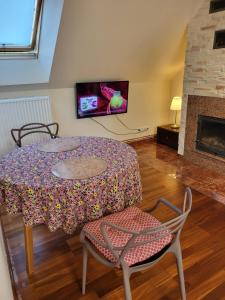 a living room with a table and chairs and a tv at Radzymin Pd Faktura Invoice Fully equipped apartment with a private parking and garden in Radzymin