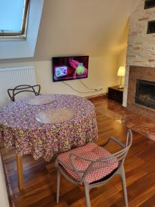 a living room with a table and chairs and a tv at Radzymin Pd Faktura Apartamenty na przedmieściach z prywatnym parkingiem i ogrodem in Radzymin