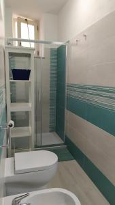 a bathroom with a toilet and a glass shower at Casetta Emilia vicino al mare in Ischia +4 photos