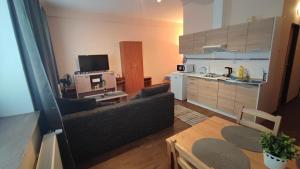 a living room with a table and a kitchen at Hotel Slávie in Trhová Kamenice