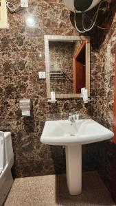 ein Bad mit einem Waschbecken und einem Spiegel in der Unterkunft منازل الماسة للشقق المخدومـة in Ha'il