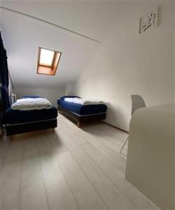 Zimmer mit 2 Betten und einem Tisch in der Unterkunft De Vlinder in Brouwershaven
