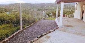 a fence in front of a house with a view at Cabañas Teodoro in Tanti