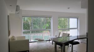 a living room with a table and two windows at Residencial Paradisus in San José