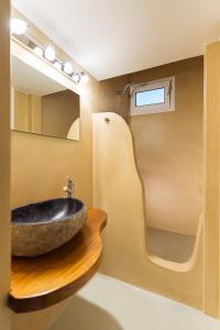 uma casa de banho com um lavatório e um espelho em Brand New Mykonos Town Suites em Míconos