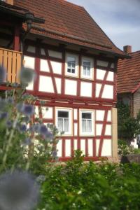 ein rot-weißes Gebäude mit zwei Fenstern in der Unterkunft Ferienwohnung Vorndran in Bischofsheim an der Rhön