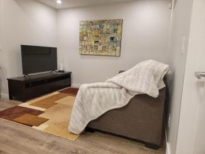 sala de estar con sofá y TV en 2-Bedroom Guest Suite en Calgary