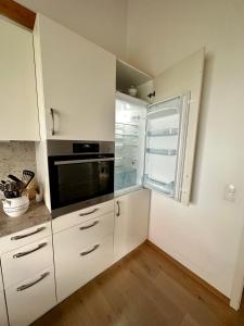 eine Küche mit weißen Schränken und einem Fenster in der Unterkunft Wiehler- Ferienwohnung in Wiehl