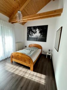 ein Schlafzimmer mit einem Holzbett in einem Zimmer in der Unterkunft Wiehler- Ferienwohnung in Wiehl