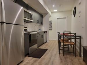 cocina con nevera y mesa con sillas en 2-Bedroom Guest Suite en Calgary