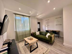 a living room with a green couch and a table at Lovely 1-bedroom flat with Patio in London