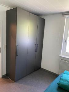 Schlafzimmer mit weißen Schränken, einem Bett und einem Fenster in der Unterkunft Ferienwohnung in Marsberg-Oesdorf 