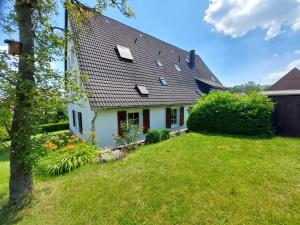 ein weißes Haus mit einem schwarzen Dach und einem Hof in der Unterkunft Ferienwohnung in Marsberg-Oesdorf 