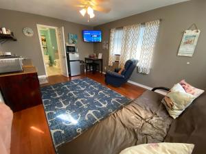 uma sala de estar com um sofá e um tapete azul em Pelican Nest-Heated Pool Jacuzzi Tub Pvt Balcony em Pensacola
