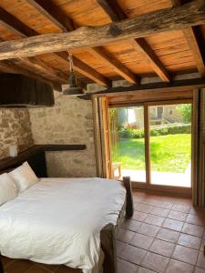 ein Schlafzimmer mit einem Bett und einem großen Fenster in der Unterkunft LA CASA DEL HORNO in Hornedo