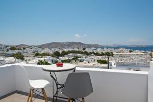 una pequeña mesa en un balcón con vistas a la ciudad en Brand New Mykonos Town Suites en Mykonos
