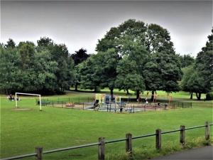 un parque con parque infantil en un campo con árboles en Luxury and lovely Cosy well equipped home with Free Parking and Free Fast WiFi en Morley