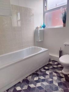 a bathroom with a white tub and a toilet at 1 bedroom apartment in Neepsend