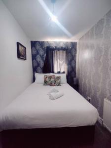a bedroom with a large bed with white sheets at 1 bedroom apartment in Neepsend