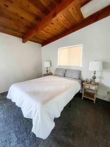 a bedroom with a large white bed and two lamps at Retreat Home Near Yosemite and Bass Lake! in Oakhurst