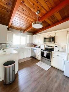 a kitchen with white cabinets and a wooden ceiling at Retreat Home Near Yosemite and Bass Lake! in Oakhurst