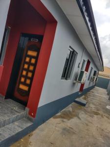 czerwono-biały budynek z drzwiami w obiekcie The Casterwells w mieście Ibadan