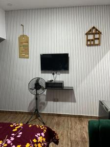 sala de estar con TV de pantalla plana y ventilador en The Casterwells en Ibadán