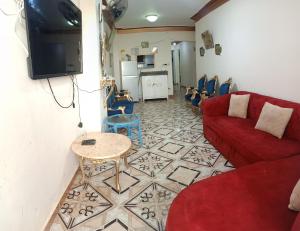 a living room with a red couch and a table at Furnished Apartment - Beach view "Nearest Beach 2 minutes walking" - Free Wifi- Abo keer - Alexandria - Egypt in Abū Qīr