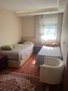 a bedroom with two beds and a chair and a window at Best site in İstanbul (3+1) Central&Elite Zone in town in Istanbul