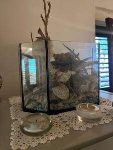 two candles sitting on a table next to a fish tank at Holiday home Stiniva in Vis