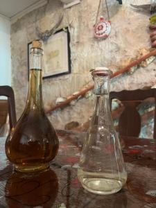 two glass bottles sitting on top of a table at Holiday home Stiniva in Vis