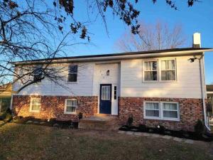 a white and red brick house with a blue door at Spacious 3 Bedroom Home in Martinsburg WV. in Martinsburg