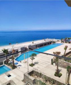 a building with a swimming pool next to the ocean at Il monte galala -Ain El Sokhna in Ain Sokhna