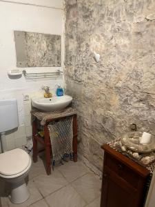 a bathroom with a white toilet and a sink at Holiday home Stiniva in Vis